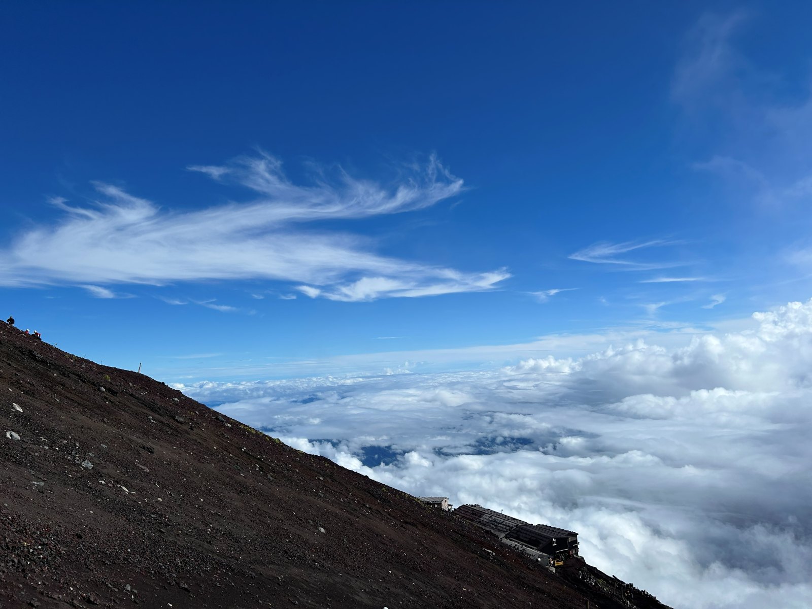青空と雲海、遠くに山小屋が見える